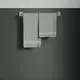 Zwei graue Handtücher hängen an einem Halter an einer dunklen Wand. Der Halter ist ein minimalistisches Design, passend zum Stil von Ideal Standard.